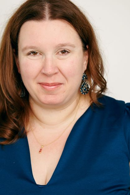 Headshot of woman with brown hair and a blue shirt